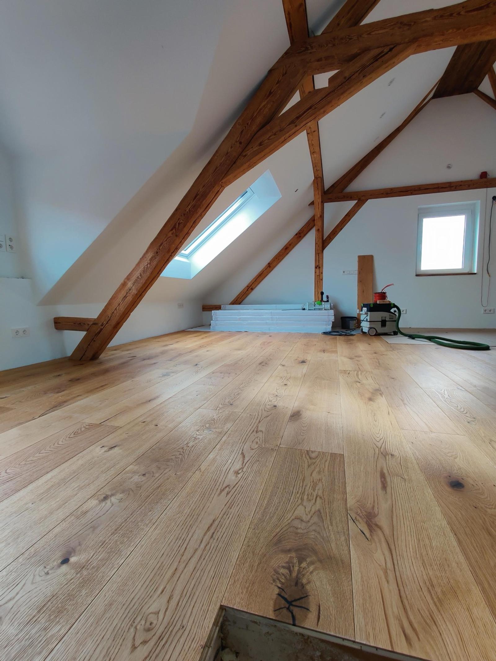 Eckige Holzdecke mit massiven Balken und hellem Eichenparkett