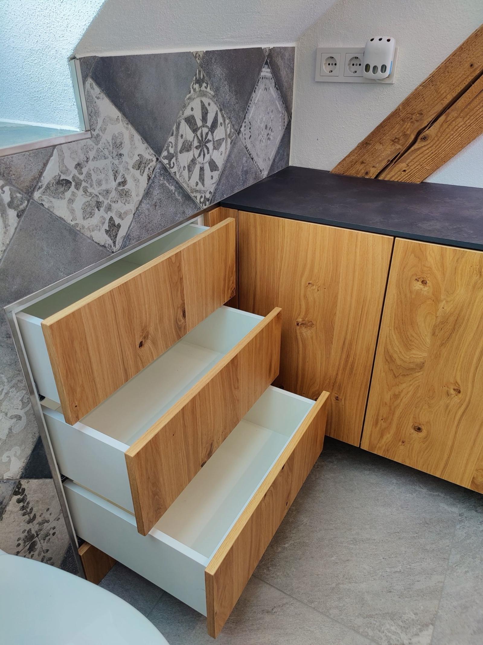 Eiche-Schrank mit offenem Schubladenbereich und Fliesenboden