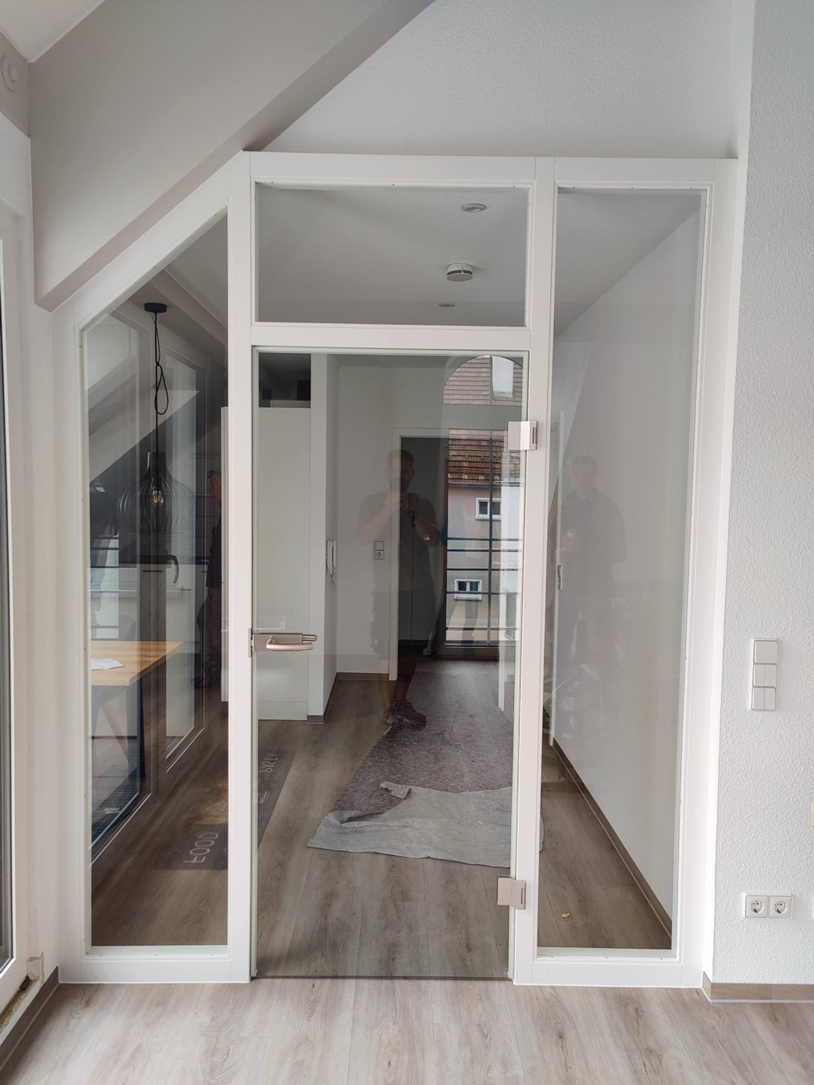 Modernes Glas-Türsystem mit weißem Rahmen und Holzfußboden