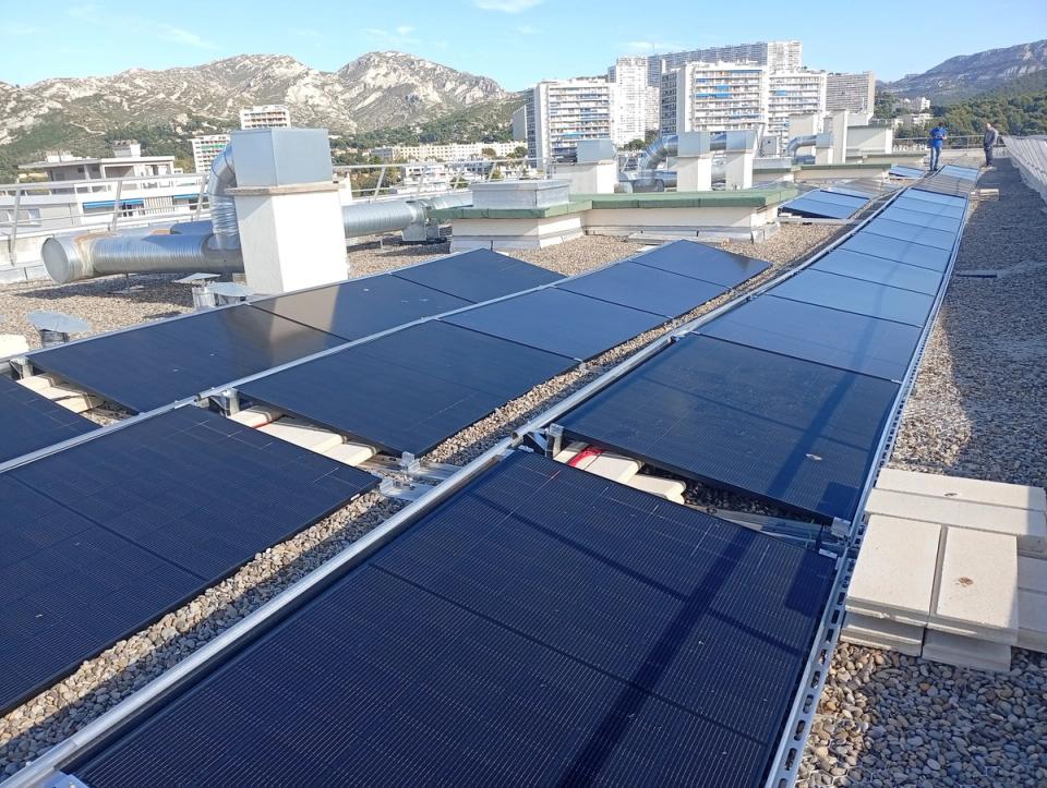 Rangées de panneaux solaires posés sur le toit de la résidence Val Marie, face aux collines du 9e arrondissement