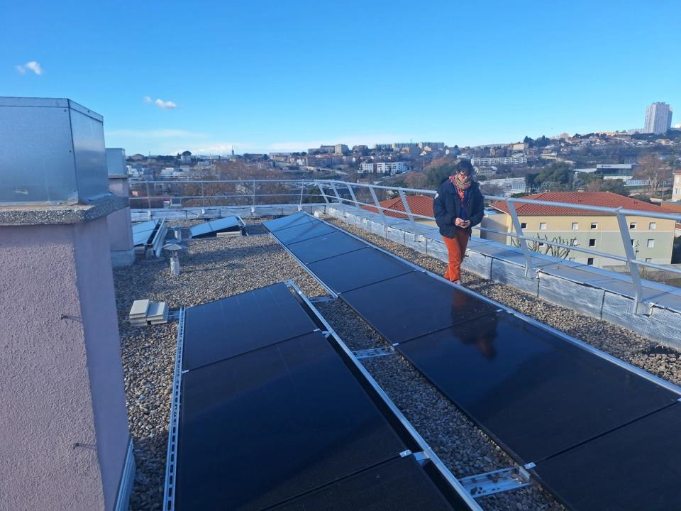Rangées de panneaux solaires posés sur le toit-terrasse de la résidence les Tilleuls, au-dessus des toits du 15e arrondissement