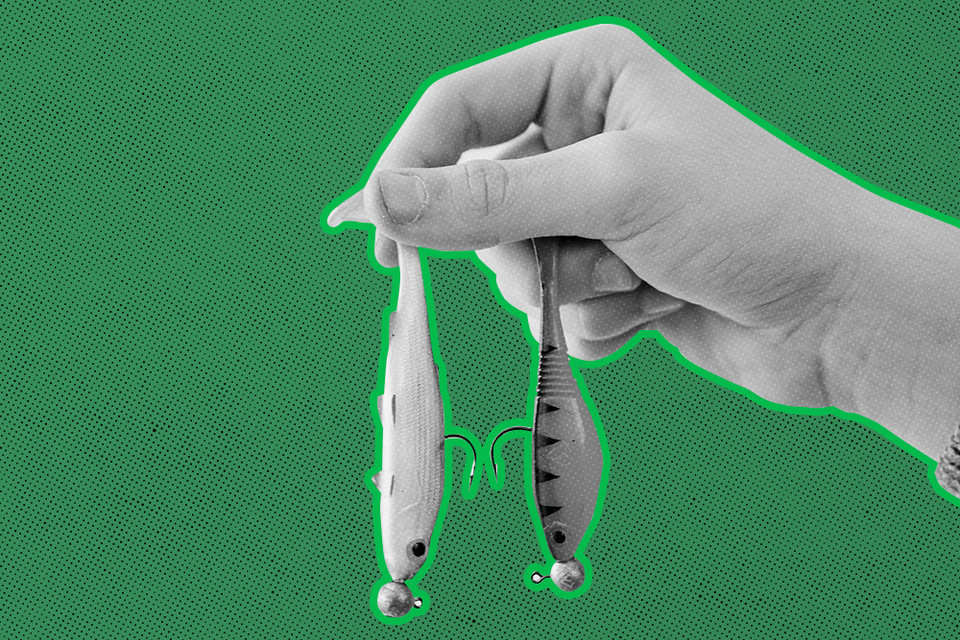 hand holding two fish hooks