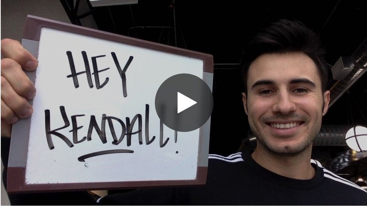 Video thumbnail of a smiling salesperson holding a handwritten whiteboard sign that reads “Hey Kendall!”