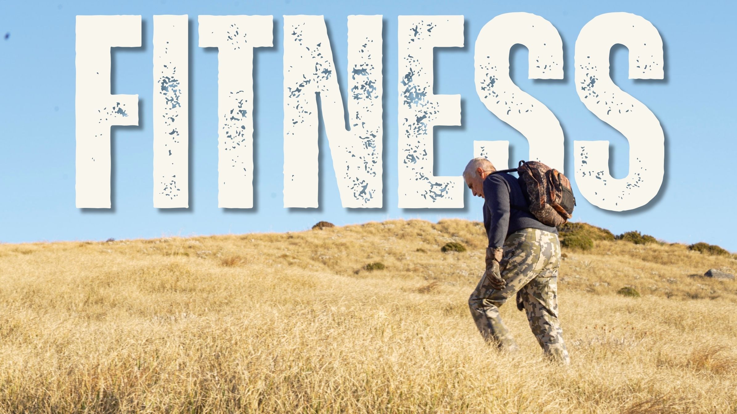 Hunter pushing uphill through golden tussock grass under a clear blue sky, with the word "Fitness" in bold distressed lettering across the top