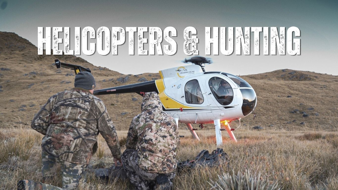 Two hunters kneel in the tussock beside a Hughes 500 helicopter in New Zealand high country, with the words "Helicopters & Hunting" in bold distressed lettering across the top.