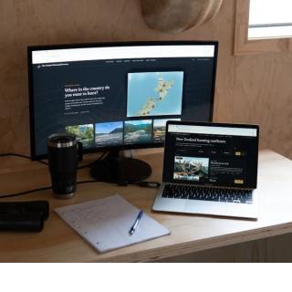 Notebook of outfitter questions beside a laptop showing the directory map, titled Choosing an Outfitter