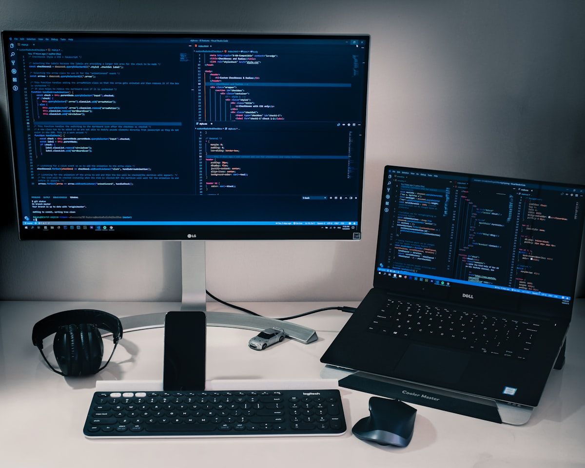 Laptop computer beside monitor with keyboard and mouse