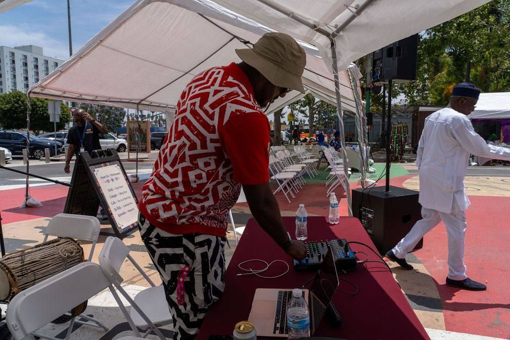 The DJ works his mixer under the tent before the seats fill