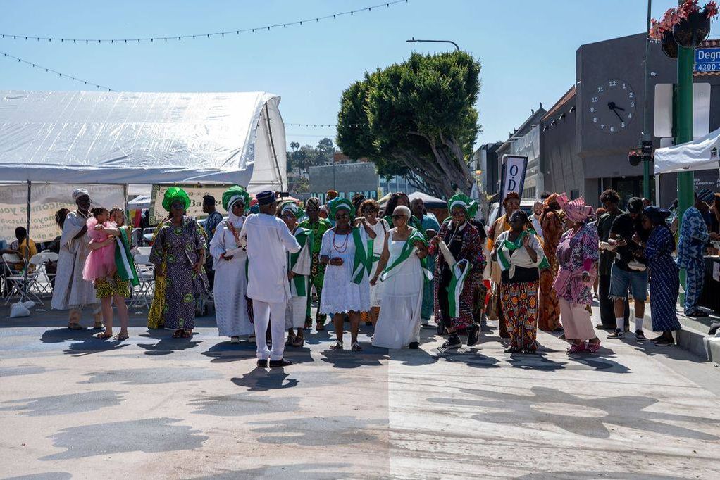 Members in white and green gather on Degnan Boulevard as the opening procession begins