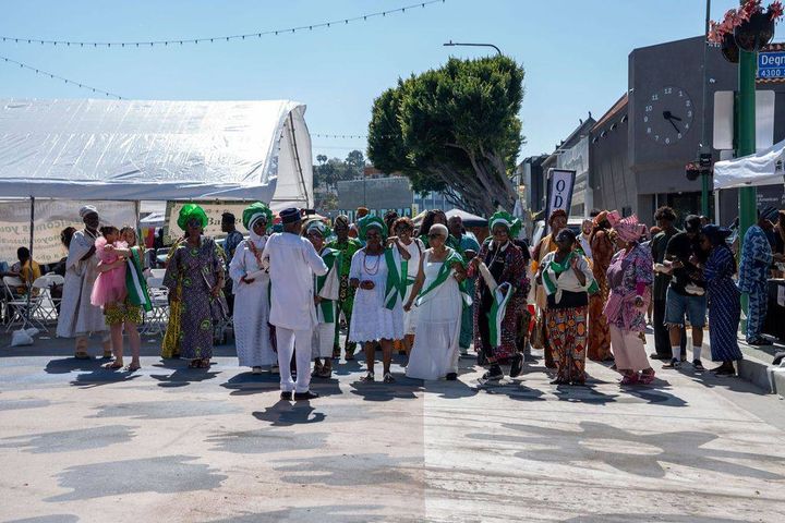 Members in white and green gather on Degnan Boulevard as the opening procession begins