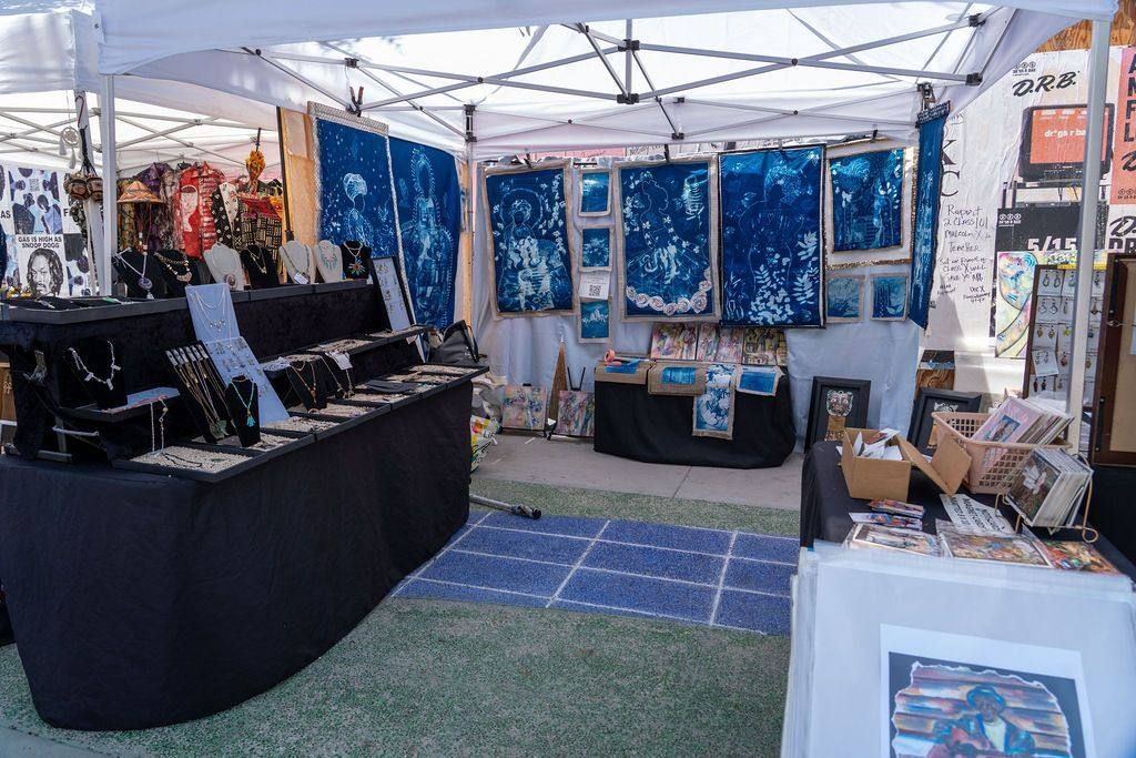 A vendor booth of cyanotype hangings, prints and jewelry