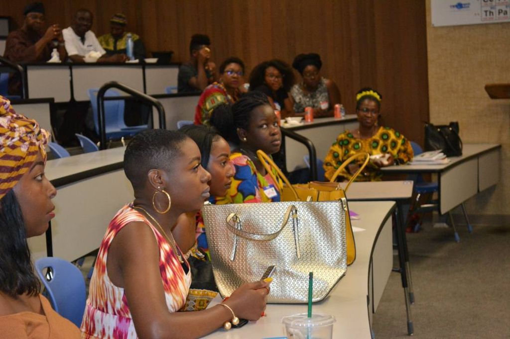 Young women listen from the front rows of the lecture hall