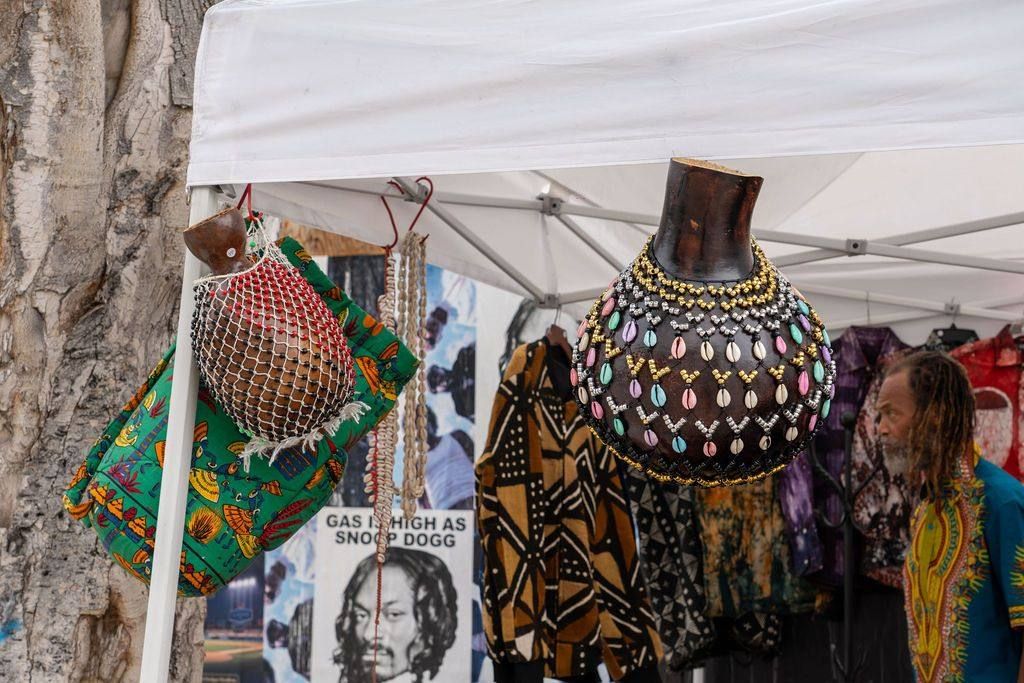 Beaded shekere gourds hang from a tent frame