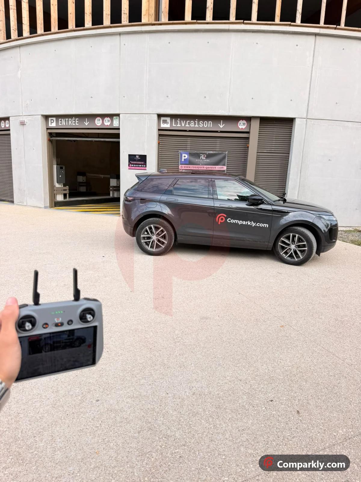 Comparkly branded car at the entrance of an indoor car park near Geneva, with a drone remote in hand