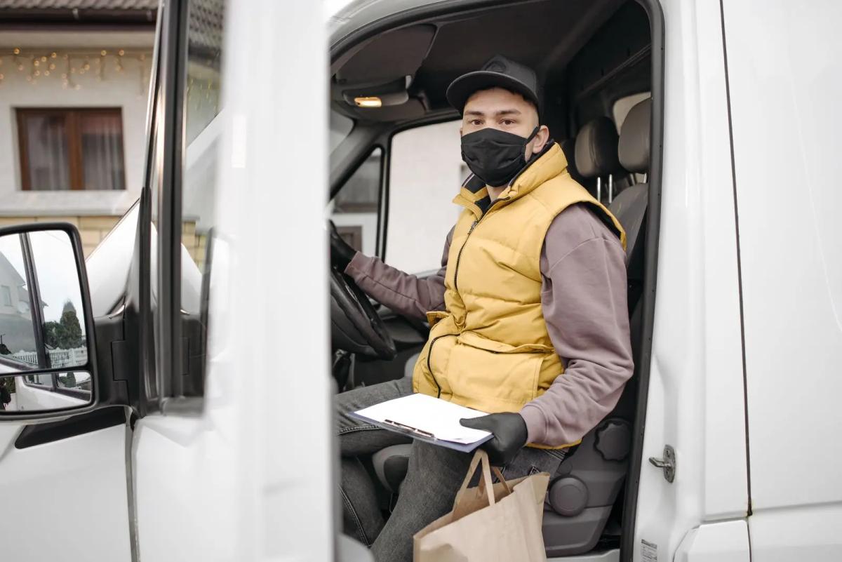 Koerier stapt uit een bestelbus met een zakelijke zending