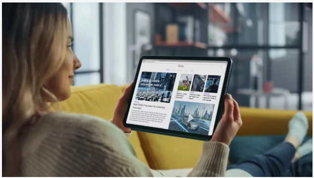 Young woman reading news on tablet