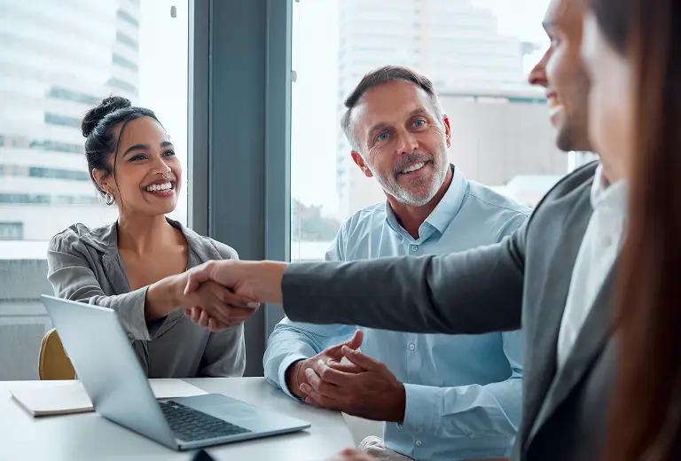 Group of people in a meeting, smiling.