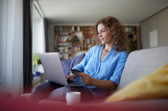 Women in blue shirt on computer in living room