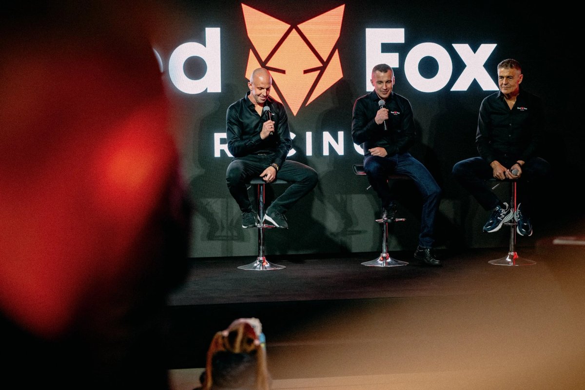 Edward Ruszczyc and Krzysztof Hołowczyc on stage at the Red Fox Racing launch with the logo behind them