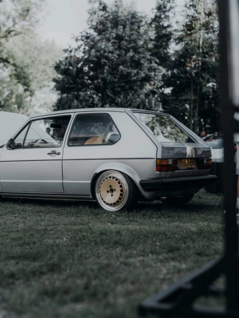 Silver Golf Mk1 on gold wheels from the rear, parked on the grass under the trees