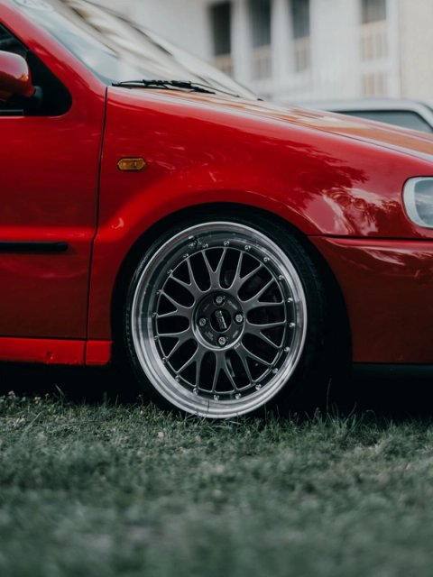 Front wheel of the red Polo GTI, a BBS split rim sitting in the grass