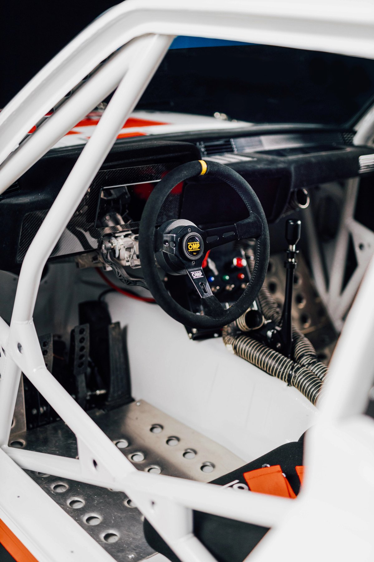 Interior of BMW E21 Group 5 showing OMP steering wheel, full roll cage and stripped cockpit