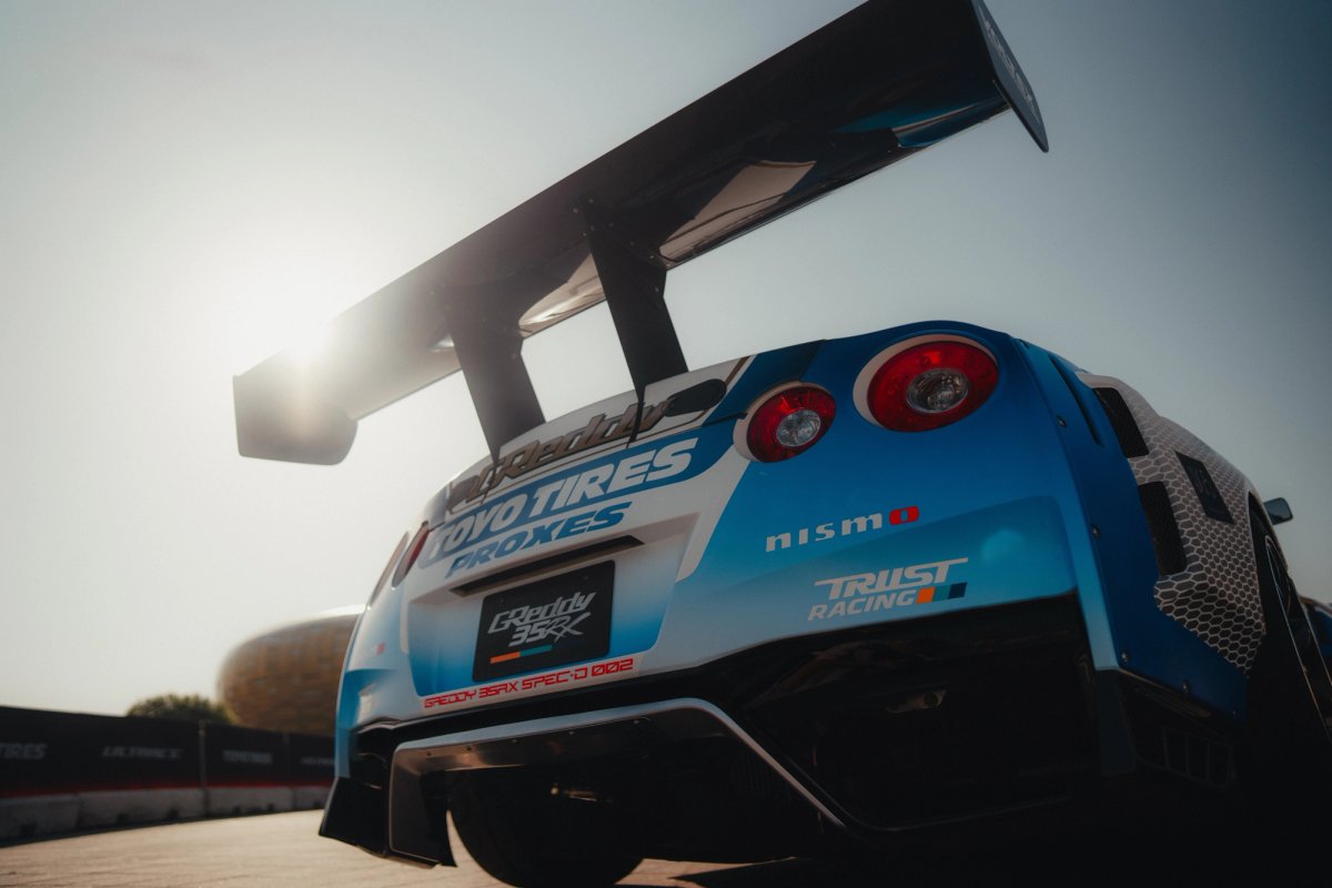 Rear low-angle of the Toyo Tires-liveried Nissan GT-R R35 with massive rear wing catching sunlight