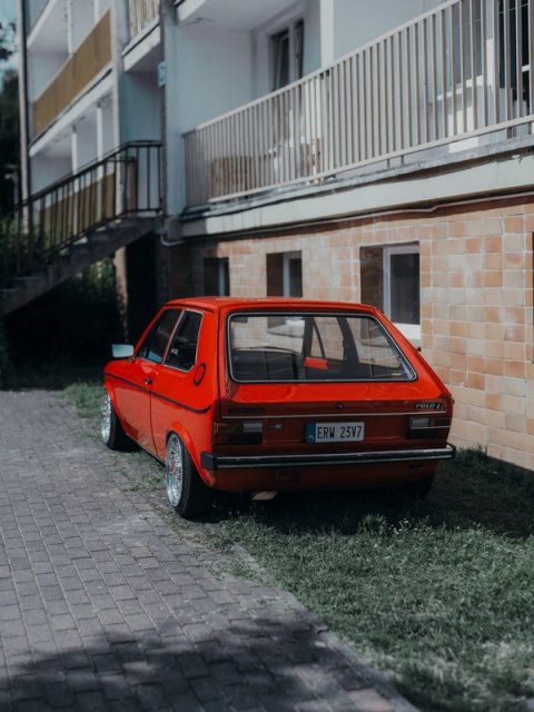 Red VW Polo L on BBS wheels parked against the tiled wall of a resort block