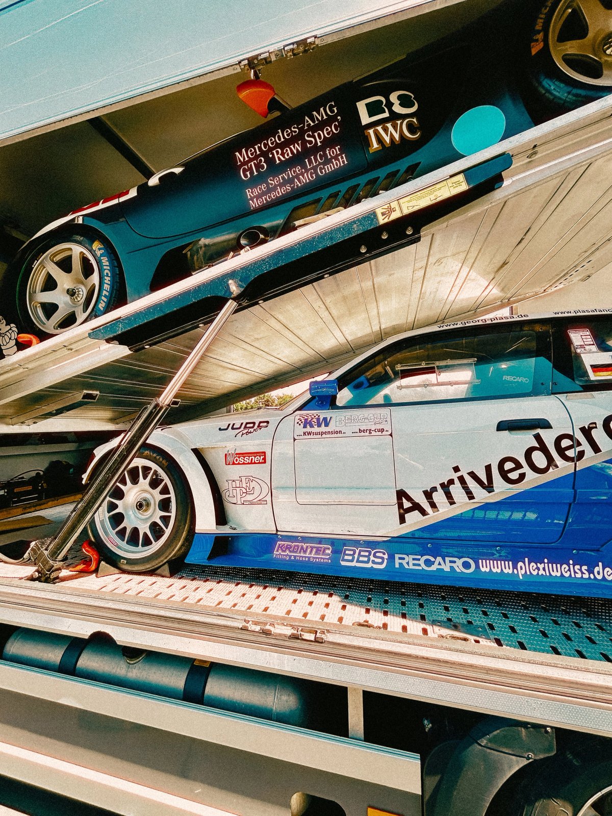 Multi-deck transporter with Mercedes AMG GT3 Raw Spec on top and BMW V12 LMR below