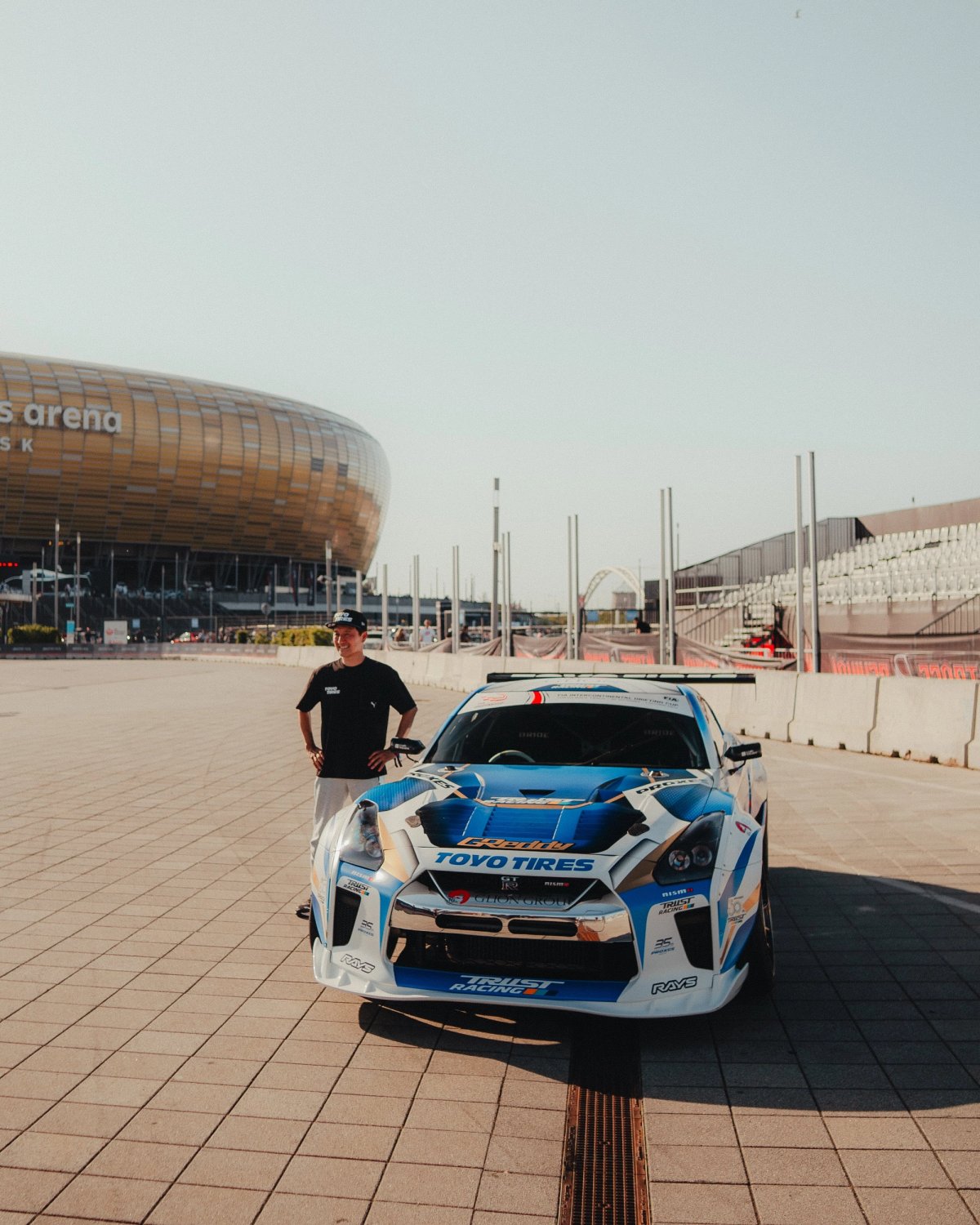 Toyo Tires-liveried Nissan GT-R R35 with the driver in front of Polsat Plus Arena