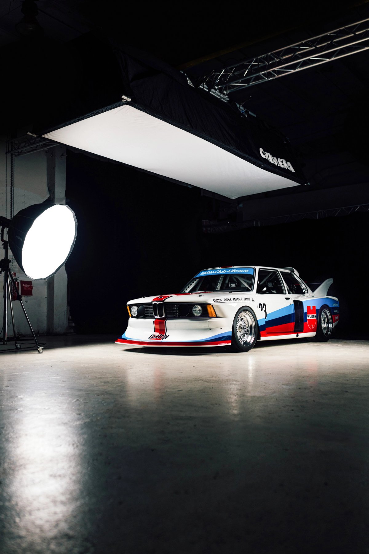 White BMW Motorsport E21 Group 5 in studio with dramatic lighting and softbox visible