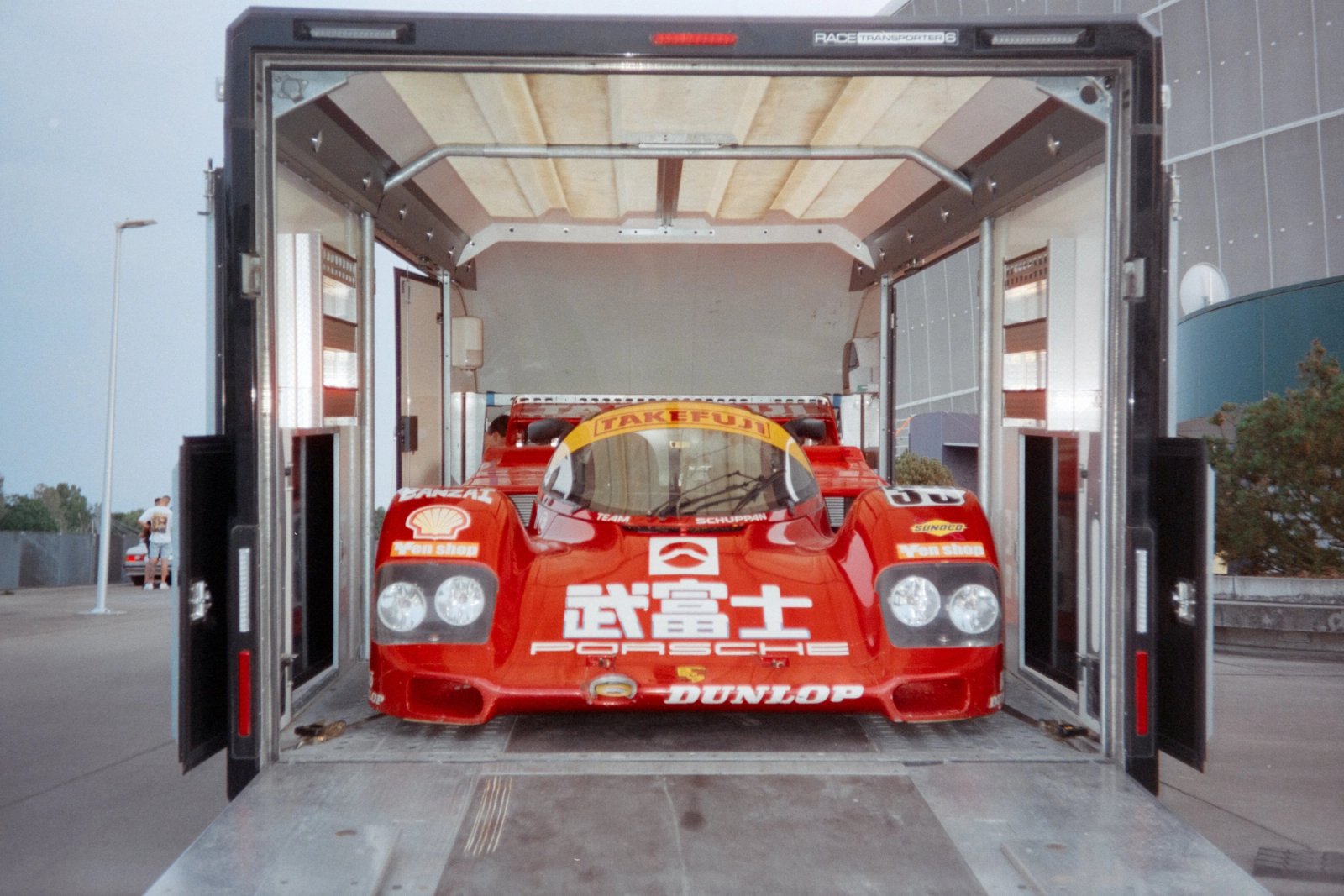 Porsche 962C Team Schuppan emerging from enclosed transporter with doors open