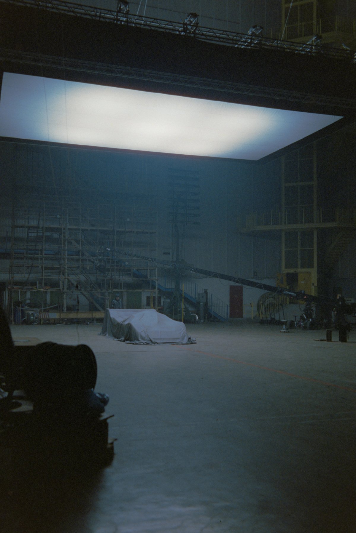 Behind the scenes: C11 under cover in the distance with massive softbox overhead and film equipment in foreground