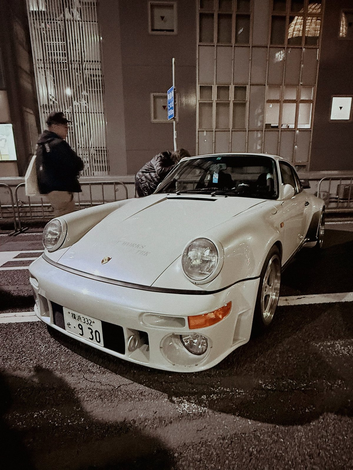 White Porsche 930 Turbo front three-quarter at night with Yokohama plate reading 930