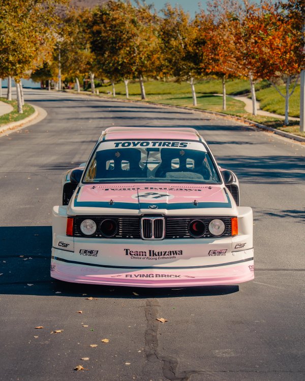 Team Ikuzawa BMW E21 head-on front view with Flying Brick on splitter and autumn trees