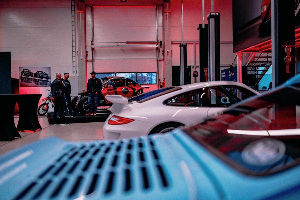 Red Fox Automotive showroom with Porsche GT3 and rebuilt Defenders under red lighting