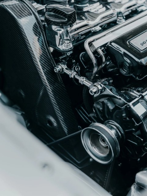 Engine bay detail with a carbon airbox and chromed valve cover