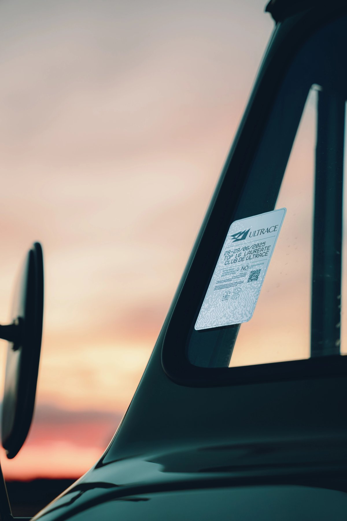 Ultrace Top 16 Laureate sticker on the Unimog windshield pillar at sunset
