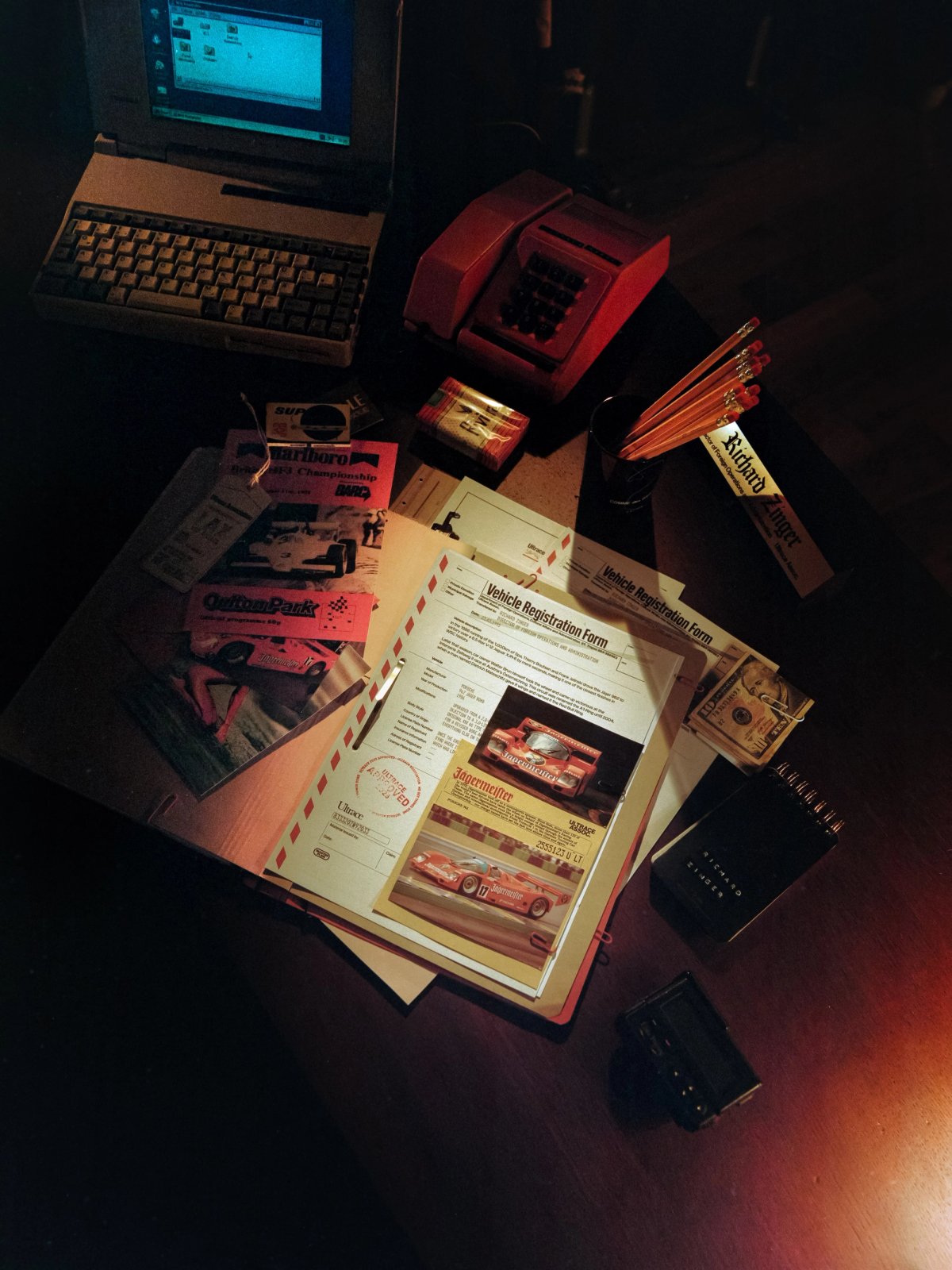 Desk with vintage computer, fax machine, car documents and 80s props from an Ultrace campaign shoot