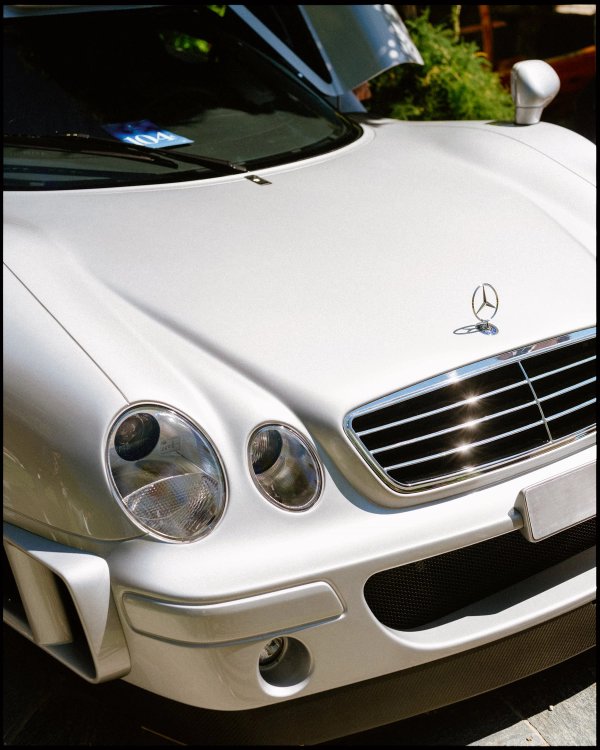 Close-up of a silver Mercedes nose with the three-pointed star and circular headlights