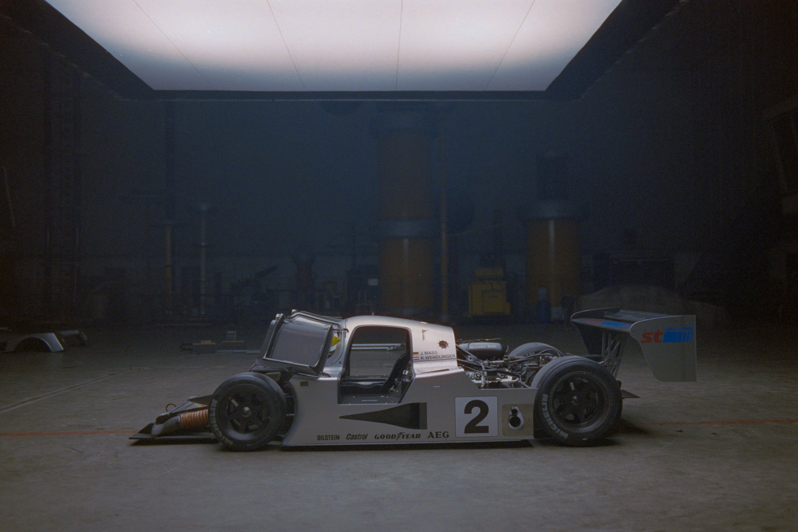 C11 fully stripped without bodywork, engine and suspension exposed, rear wing placed to the side