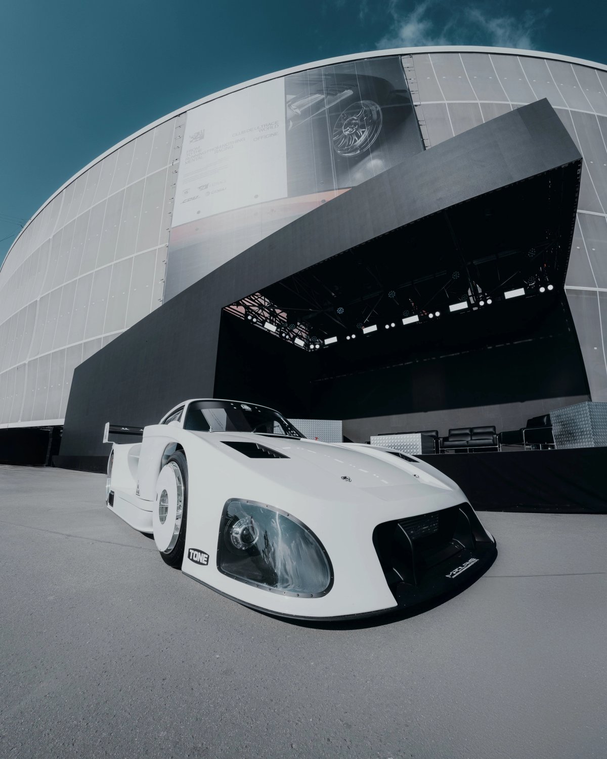 White Madlane 935ML from low angle at Ultrace with stage structure behind