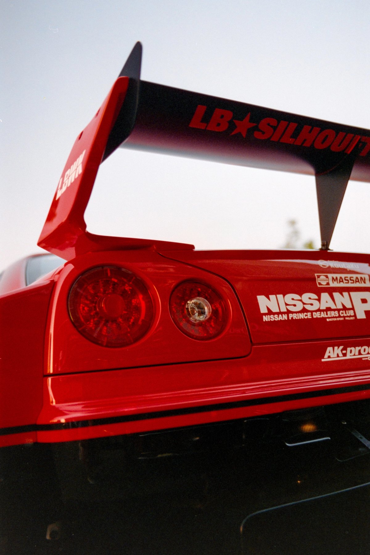 Red Nissan Skyline rear detail with LB Silhouette wing shot from below on film