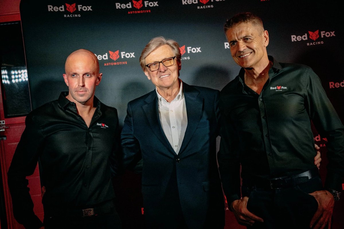 Edward Ruszczyc with two Red Fox Racing team members posing in front of the Red Fox backdrop