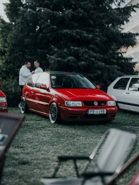 Red Polo 6N GTI on BBS wheels standing on the grass, two men talking behind it