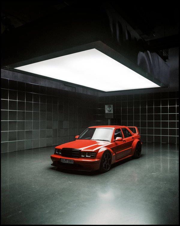 Front three-quarter of HWA EVO in red, parked under a large suspended softbox in a black-tiled room, plate reading LB-PT 1004