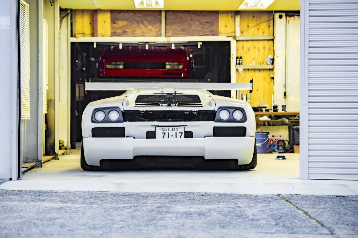White Lamborghini Diablo and red Ferrari Testarossa inside the Madlane garage