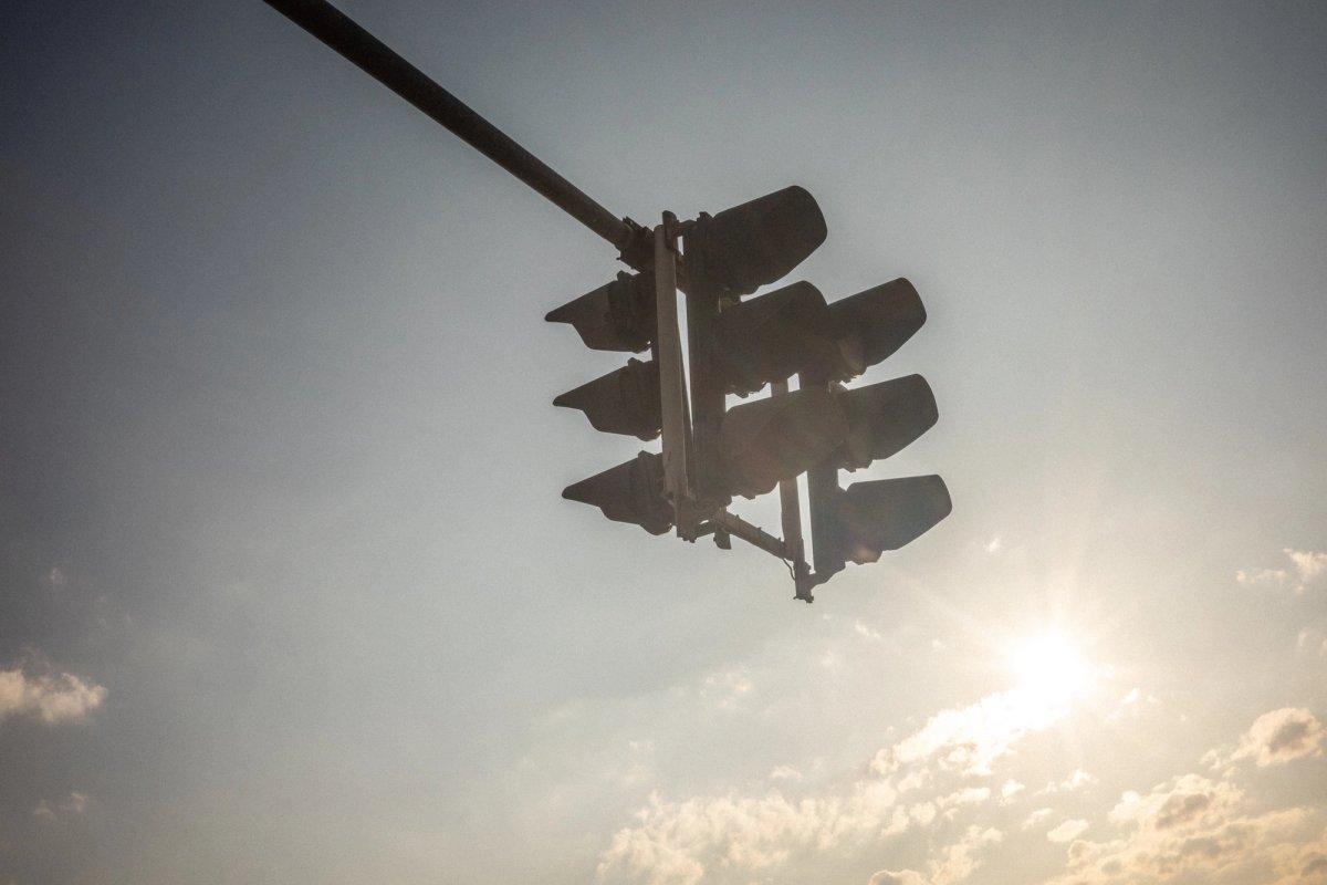 Traffic light silhouette against the sun before the first drive