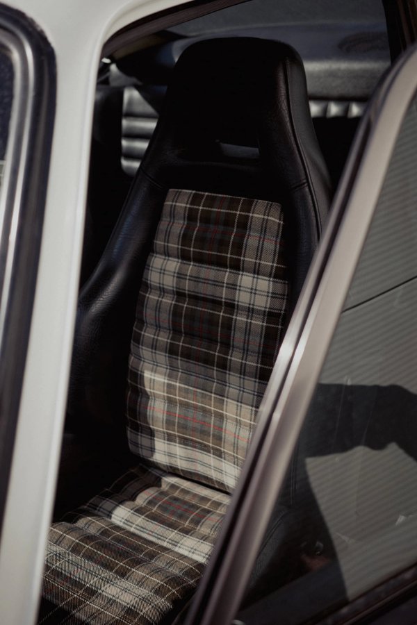 Close-up of tartan sport seat in white Porsche 911 G-series through open door