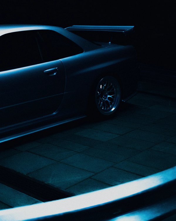Matte black Nissan Skyline R32 GT-R at night with cool blue light streaks